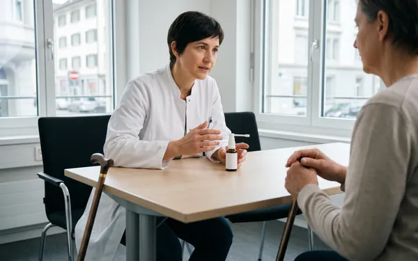 Aerztin erklaert einer Patientin mit Multipler Sklerose in einer Schweizer Praxis die Anwendung von Sativex Spray zur Behandlung von Spastizitaet