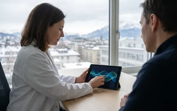 Neurologische Ärztin in Schweizer Praxis erklärt einer Epilepsiepatientin sachlich die Möglichkeit einer CBD-basierten Cannabis-Therapie am Tablet